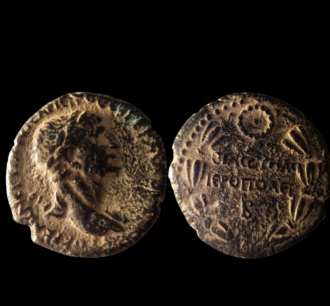 Roman Empire: Title: Roman Empire Description: Roman Provincial Bronze Coin of Emperor Trajan (98-117 AD), minted in Hieropolis. Obverse: Laureate and cuirassed bust of Emperor Trajan facing right, wearing paludame
