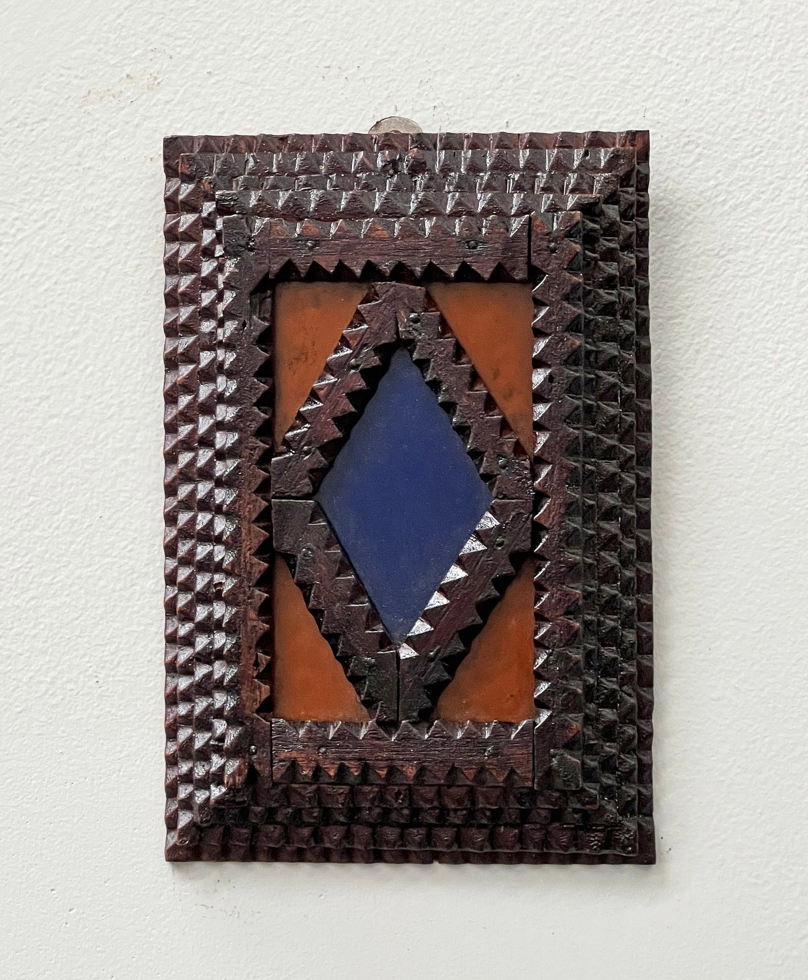 Tramp Art Frame with Colored Glass: Title: Tramp Art Frame with Colored Glass Description: A tramp art frame with colored glass inserts. It appears that the frame was meant to house the blue glass in the center. Colored glass in tramp a