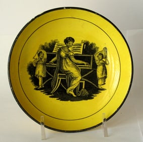Antique canary yellow pottery tea bowl with black transfer.