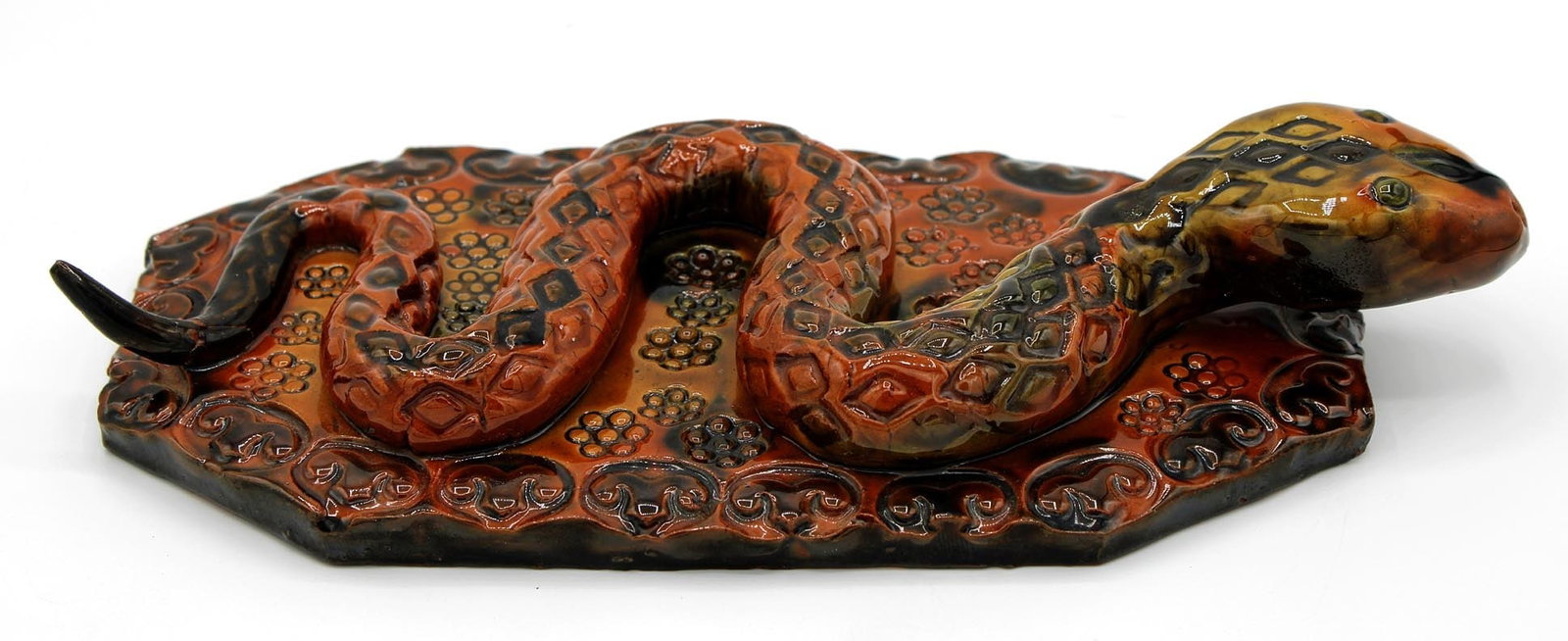 A redware pottery snake with embossed and glazed decoration.: This is a redware pottery snake with embossed and glazed decoration. It measures 9 1/4" long by 4 1/4" wide by 1 3/4" high. The bottom is signed "James J. Nyeste 1987 Seven Valleys, PA". The tip of th