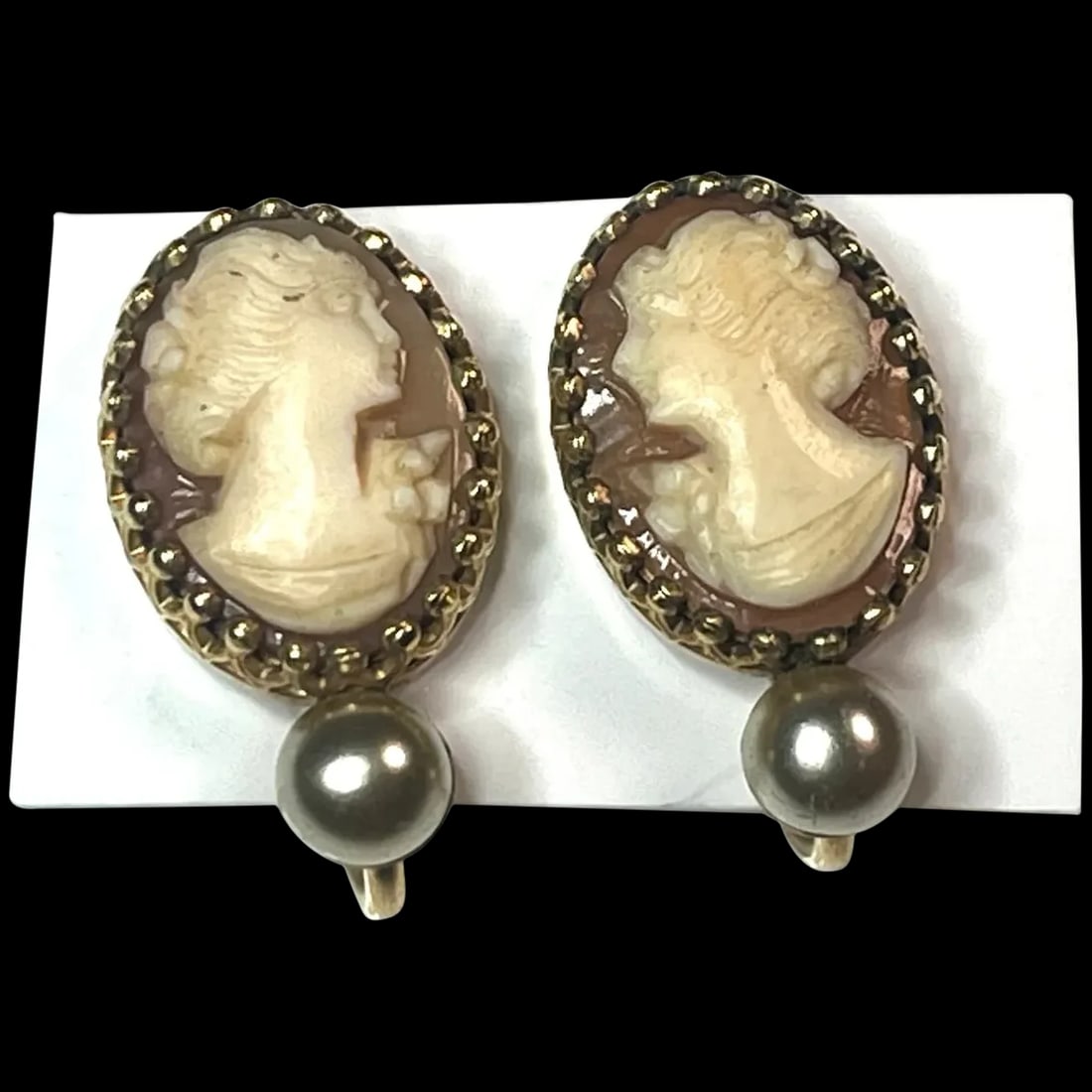 Vintage Simmons Cameo Screw Back Earrings: Title: Vintage Simmons Cameo Screw Back Earrings Description: Vintage Simmons Cameo Screw Back EarringsHallmarked Simmons, Unknown MetalWeighs 4 grams Measures .75 x .50 inches Date/Period:Vintage Mat