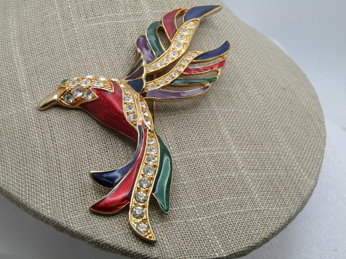 Large Enameled Rhinestone Bird Brooch, 5", 1980's-1990's: Large Enameled Rhinestone Bird Brooch, 5" tall and 2.75" wide. , 1980's-1990's. Gold tone back and framing with rhinestones set in the wings andneck. Enameled in rich dark blue, red, and green with a 