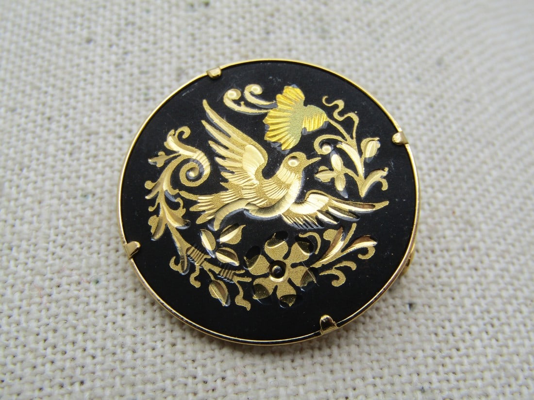 Vintage Damascene Bird Brooch, Trombone Clasp, 1960's-1970's: Vintage Damascene Bird Brooch, Trombone Clasp, 1960's-1970's. Gold tone with black background and gold etched design of a bird and flowers and leaves. It is appx. 1-1/8" round. Very good and clean con