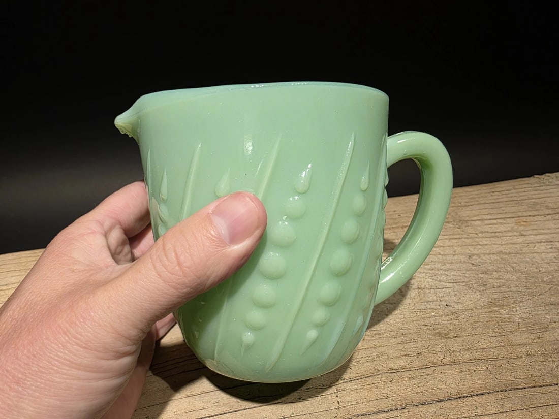 Jadeite Depression Glass Retro Beaded Milk Pitcher: Reproduction never used Jadeite beaded milk pitcher, a type of jade green opaque milk glass popular in the United States in the early to mid-20th century. This pitcher, produced by Anchor Hocking unde