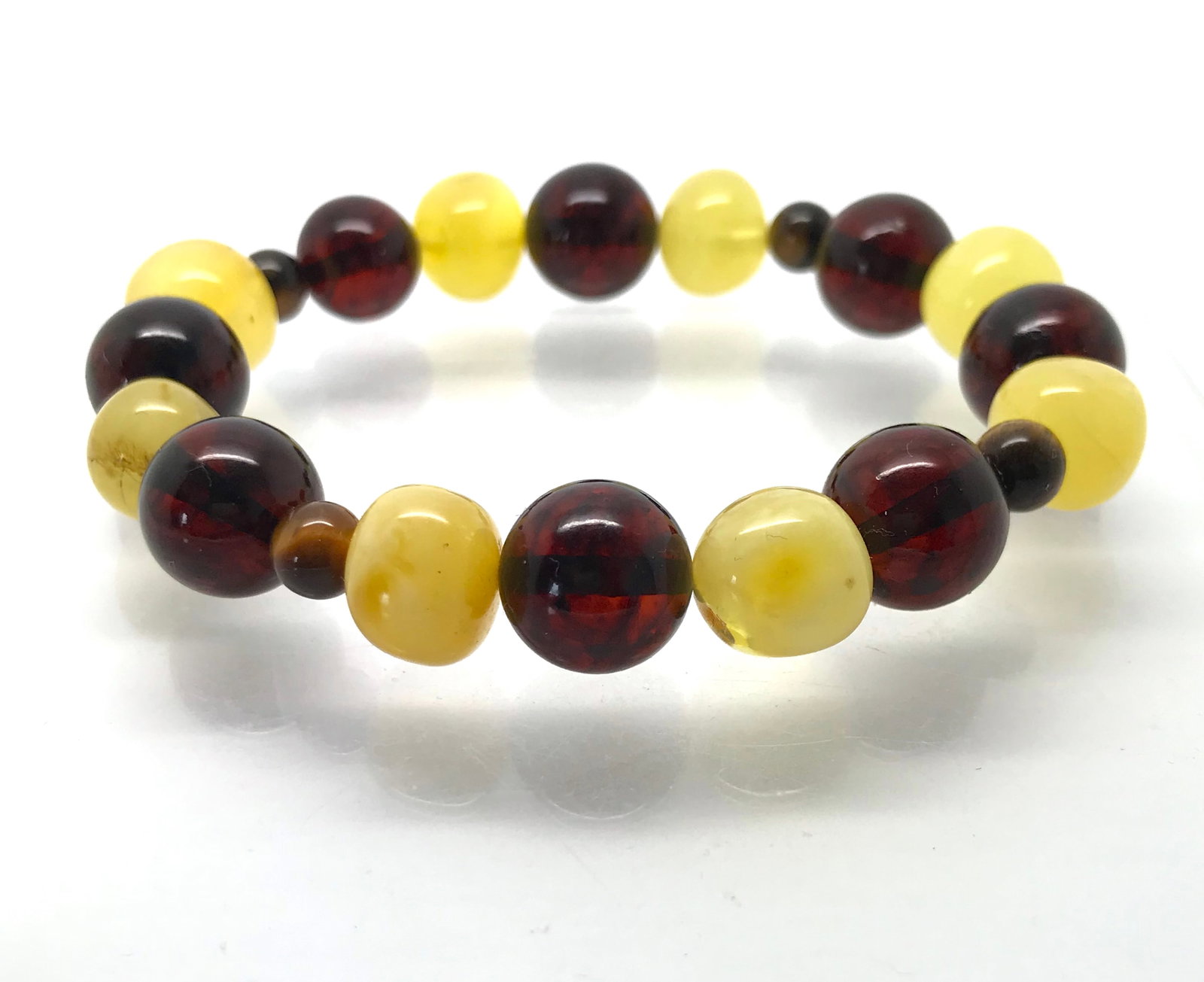 Bracelet Baltic amber & Tiger eye's: Title: Bracelet Baltic amber & Tiger eye's Metal: None Gemstones:Amber Weights:15.4 g Size:Bead size: 12.0 mm Bead size: 0.472 inches Made of:(Reconstituted Amber or Whole Stone):Whole Stone Additiona