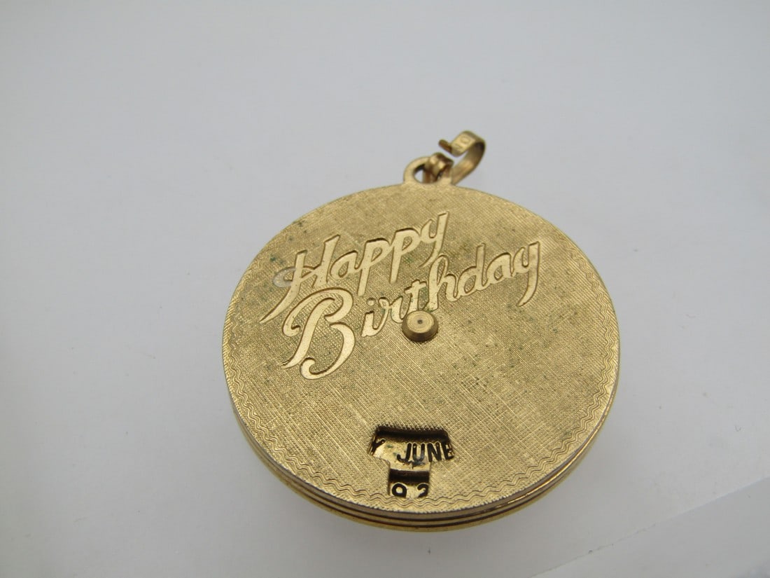 Vintage Monet Happy Birthday Pendant, Changeable Date, 1960's: Vintage Monet Happy Birthday Pendant, Changeable Date, 1960's. It is gold tone and signed Monet on the bail. textured front and back with recessed smooth Happy Birthday on an angle and a Monday and da