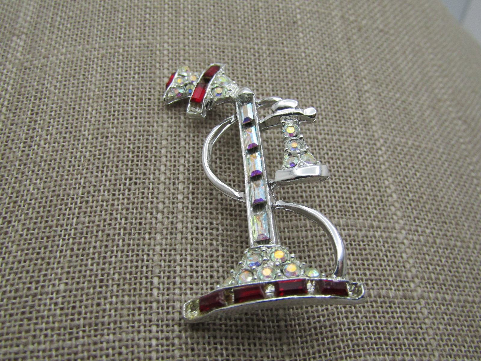 Vintage Red Clear Rhinestone Telephone Brooch, 1960's: Vintage Red Clear Rhinestone Telephone Brooch, 1960's. This is silver tone with round and baguettes with aurora borealist shimmer. Silver tone is 2" tall and 1.25" wide. Red rhinestone baguettes in th