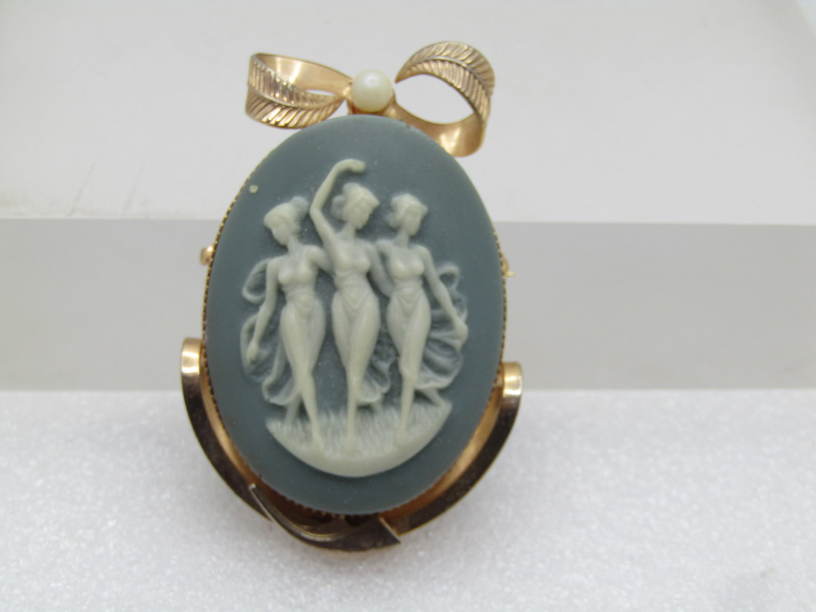 Vintage Green Cameo Three Graces Brooch With Bow, 1960's.: Vintage Green Cameo Three Graces Brooch With Bow, 1960's, gold tone, 2" by 1.5". Gold toned bow on top with 4mm faux pearl. Locking clasp. Very clean and good condition. It is not signed by the maker.