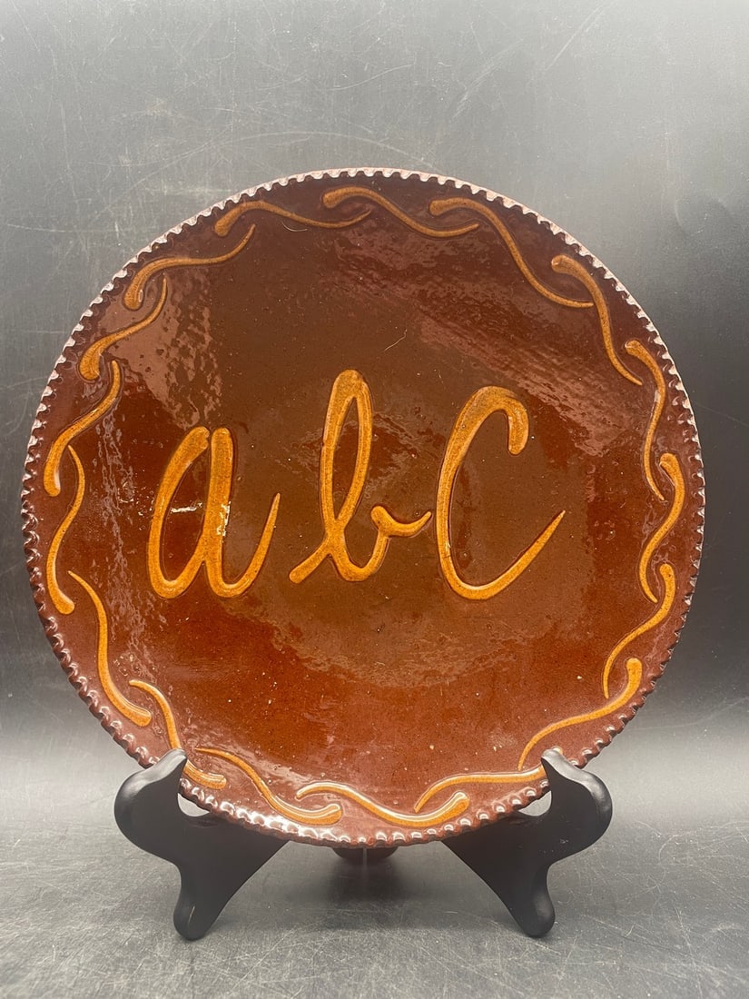 1988 Ned Foltz Redware ABC Slip Decorated Plate w/ Coggled Edge: Title: 1988 Ned Foltz Redware ABC Slip Decorated Plate w/ Coggled Edge Date/Period: 1988 Dimension: Approx. 7.5" diameter Material: redware Additional Information: 1989 Ned Foltz Redware ABC Slip Deco