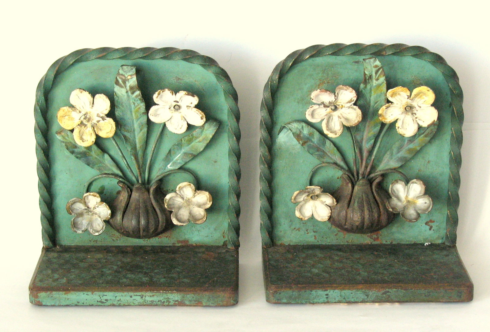 Antique cast iron stylized flowers bookends.: Title: Antique cast iron stylized flowers bookends. Date/Period: 1930's Dimension: 4” x 4 1/2” Additional Information: Nice antique cast iron stylized flowers bookends in great original pa