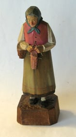 Antique folk art wood carving of a woman with her knitting.