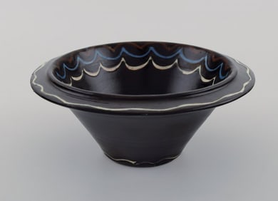 Kähler, Denmark. Bowl in black glazed ceramics with blue and white waves along the edge. 1930s