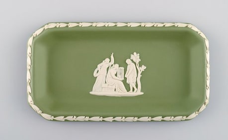Wedgwood, England. Small square dish in green stoneware with classicist scenes in white. Approx.