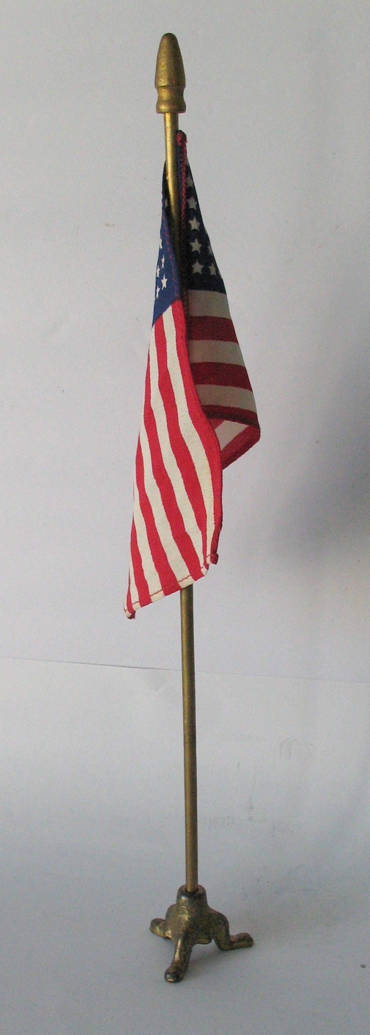 Vintage deck flag with cast iron base.: Title: Vintage deck flag with cast iron base. Date/Period: 1950's Dimension: 13 1/2” high Additional Information: Nice vintage desk flag with a cast iron base and old gold paint in original cond