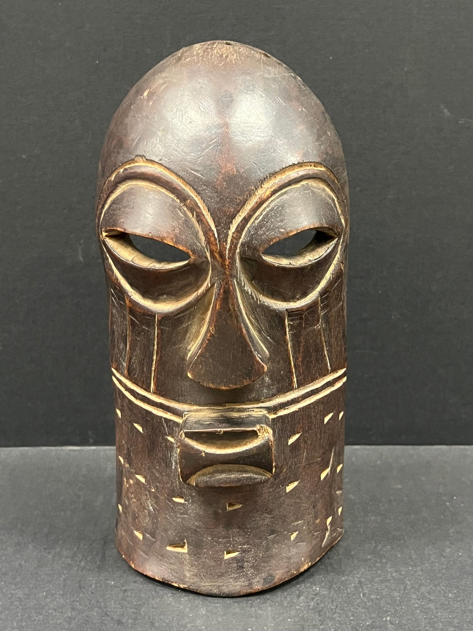 Songye Mask: Title: Songye Mask Date/Period: Late 20th Century Dimension: 11" h x 5.25" w Material: Wood Additional Information: African Art Carved Wood Songye Mask Reserve: $40.00 Shipping: Domestic: Flat-rate of