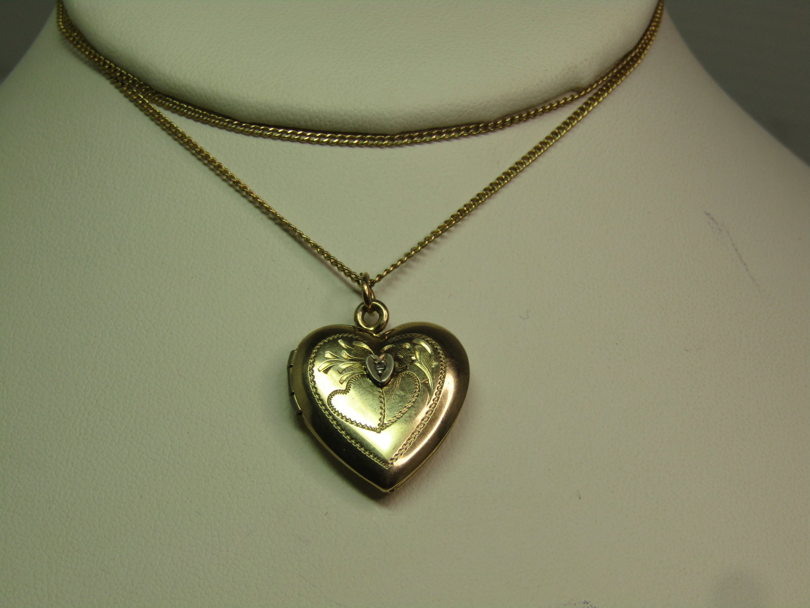 Sterling and 12kt G.F. Heart Locket, with Diamond, Signed A.L.L. Co. 1940's: Sterling and 12kt G.F. Heart Locket, with Diamond, Signed A.L.L. Co. 1940's. The heart has an engraved heart and flowral etchings on the locket with a silver tne smaller heart set on top with a small 