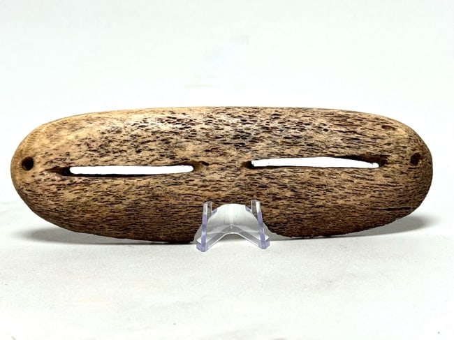 Eskimo Snow goggles - Bone - INUIT - Alaska: Authentic primitive Inuit Eskimo snow goggles from Alaska, worn to prevent snow blindness. Contemporary example in good, used condition. Rare. Dim: 15,5 x 5 x 1,5 cm. Stand included. Made of animal bo