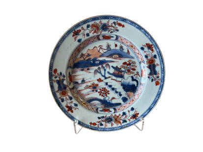 PLATE - INDIA COMPANY - QIANLONG (1736-1795): Chinese porcelain, India Company, Qianlong reign (1736-1795). "Imari" decoration in shades of blue, iron rouge, and gold, depicting a landscape. Minor restoration. Diameter: 22.5 cm. Reserve: