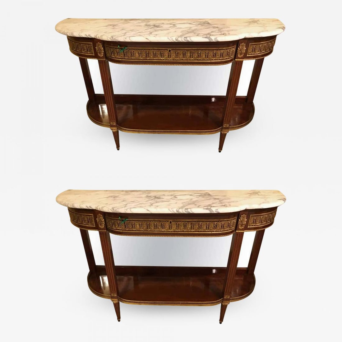Pair of Jansen Style Marble-Top Bronze Mounted Consoles: Description: Pair of Jansen style marble-top bronze-mounted consoles. A pair of Maison Jansen demilune form console tables. Simply the finest triple “D” form bronze-mounted mahogany consol
