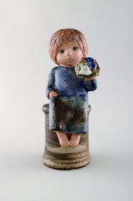 Lisa Larson for Gustavsberg. Girl with flowers in glazed ceramics. 20th century.