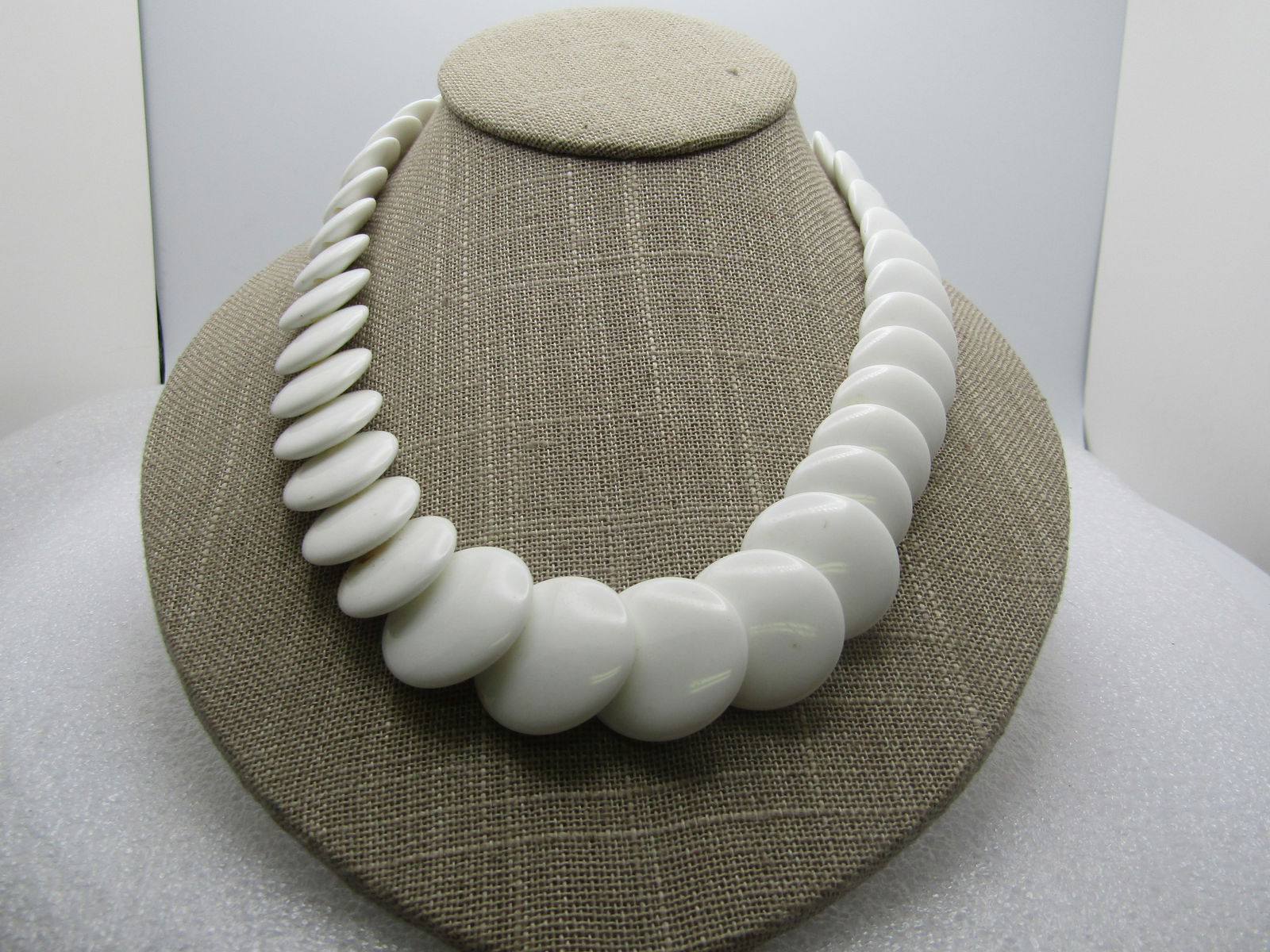 Vintage White Graduated Lucite Necklace, Trifari, 24", 1960's: Vintage White Graduated Lucite Necklace, Trifari, 24", 1960's Round beads at the clasps that range from 7.5mm to 9mm and then graduated white disc beads that range from 15mm to 23mm. Spring clasp. Ver