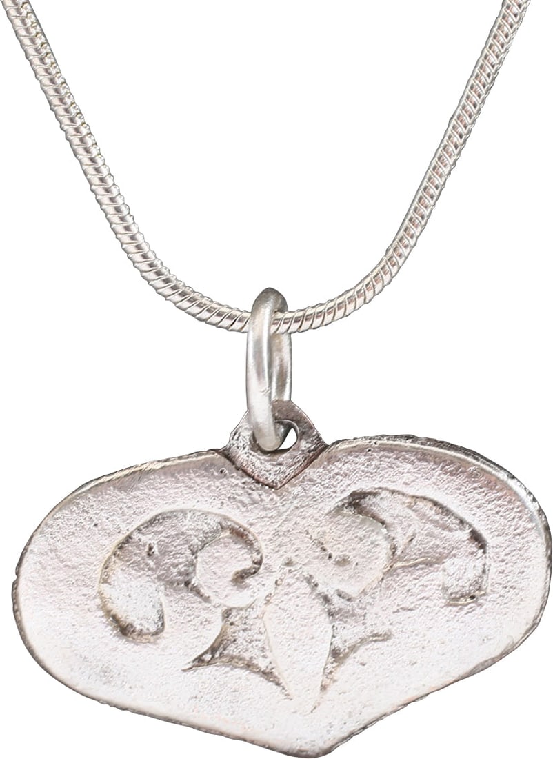 VIKING HEART PENDANT NECKLACE, 900 AD JEWELRY: An early example of a broad evolutionary form with a cusped top, formed from addorsed scrolling foliate continuing as a trefoil in the field. The trefoil was a favorite Viking form. The cusped top hea