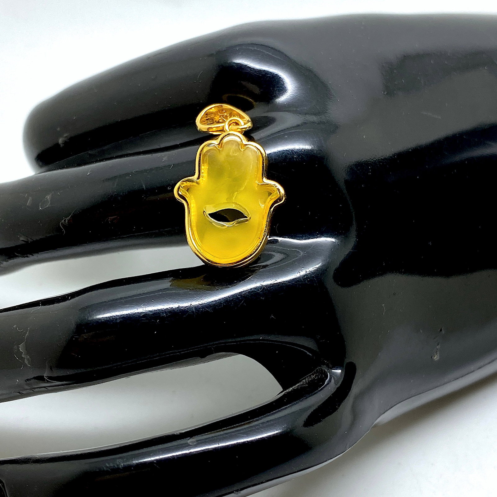Staggering Amber Pendant shaped like Hamsa / Hand of Fatima: Title: Staggering Amber Pendant shaped like Hamsa / Hand of Fatima Metal: Sterling Silver Gemstone: Amber Size: Size: 26.0 x 15.0 x 5.0 mm Weight: 86 Made of: (Reconstituted Amber or Whole Stone): Who