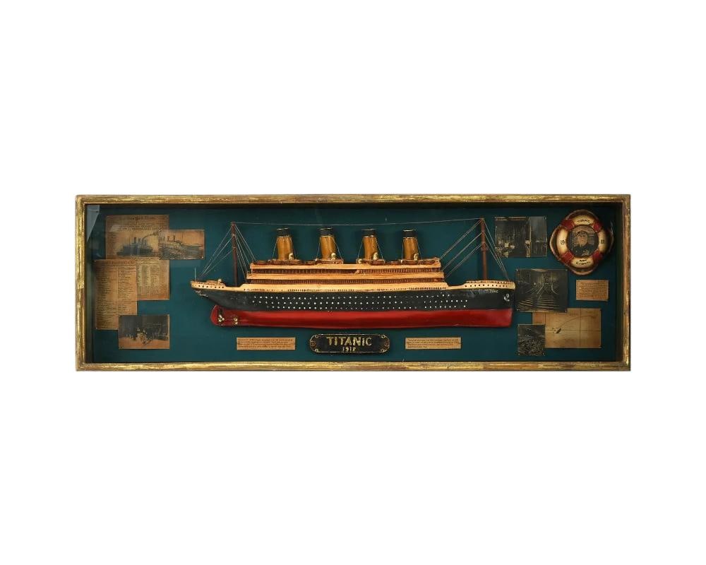Vintage 1912 Titanic Model Ship In Glass Shadow Box: A vintage 1912 Titanic model ship memorabilia. Presented in a wooden and glass shadow box. Materials: wood, metal, paper, glass, plastic. The background is adorned with newspaper front pages and photo