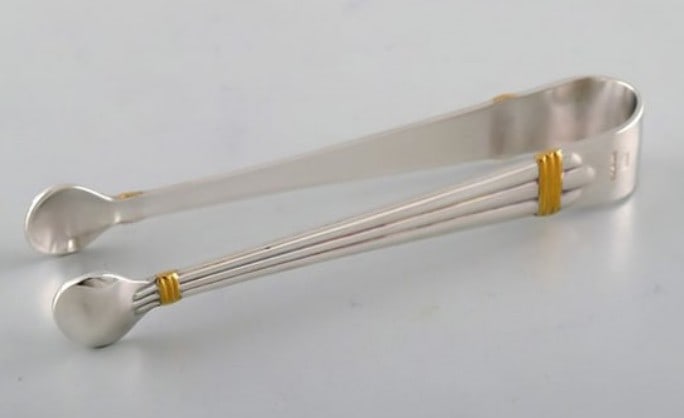 Bernard Yot for Christofle Aria sugar tong in plated silver with gold accent.: Title: Bernard Yot for Christofle. Aria sugar tong in plated silver with gold accent.Description: Bernard Yot for Christofle. Aria sugar tong in plated silver with gold accent. Measures: 11.5 cm. In v