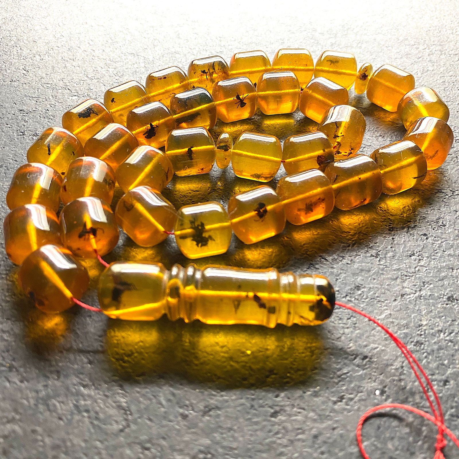 Amber Tesbih made from Barrel shaped Amber beads with inclusions: Title: Amber Tesbih made from Barrel shaped Amber beads with inclusions Metal:None Gemstone: Amber Weight:55.7 g Size:Bead size: 13.5 x 12.5 mm Bead size: 0.531 x 0.492 inches Made of: (Reconstituted