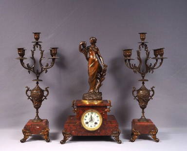 Antique French Le Creusot Marble Mantel Clock Candlesticks Garniture Set WORKS: This is a wonderful Antique Mantel Clock and Candlesticks set made in France! The set has a beautiful red marble base. The clock has a woman figure on top. The metal ornaments are spelter but I am not