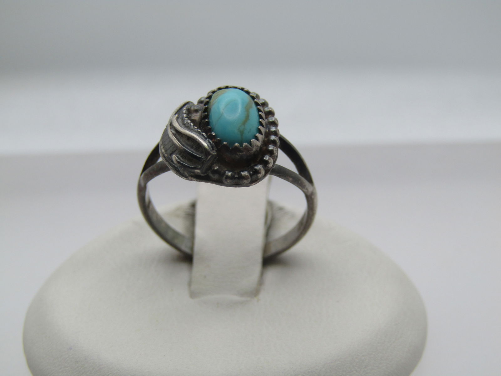 Vintage Sterling Southwestern Turquoise Ring, 5.5, 1960's-1970's: Vintage Sterling Southwestern Turquoise Ring, 5.5, 1960's-1970's. Sawtooth bezel-set turquoise oval stone that is appx. 9.5mm by 4mm. There is a curved feather off to the one side and a wider base set