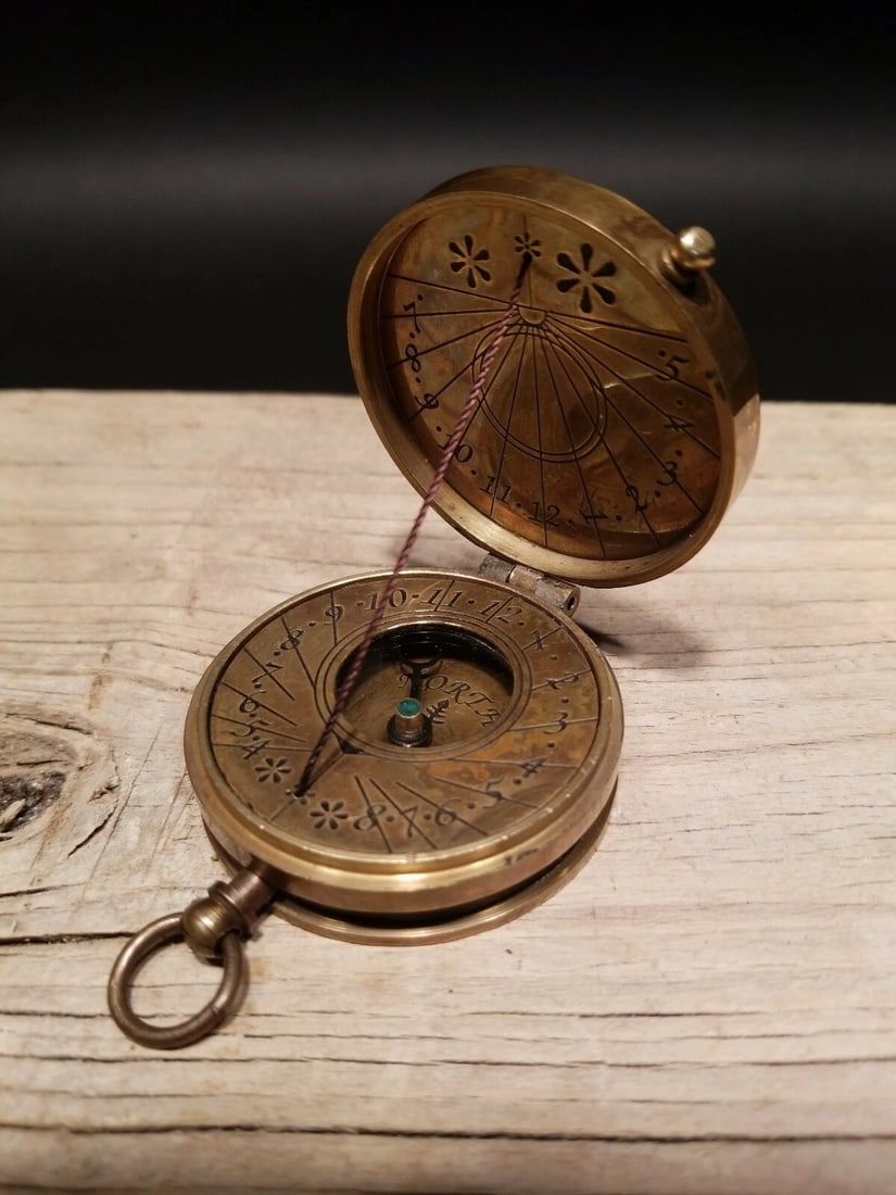 Brass Sundial Compass: 2" Nice antique reproduction sundial compass. To use on a sunny day you would face north and the shadow cast on the face of the compass will reveal the time. From what I understand you may need to com
