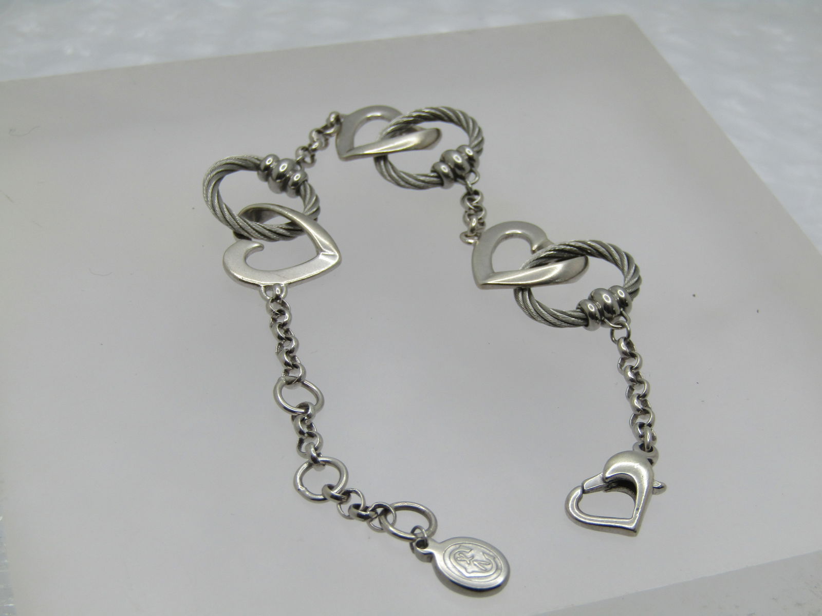 Charriol Sterling Interlocking Heart & Cable Bracelet, 6"-7": Charriol Silver Interlocking Cable & Heart Bracelet, 6"-7". Charriol is produced in Switzerland. Charriol makes jewelry in both sterling and some in stainless and other alloy. They are treated with hy
