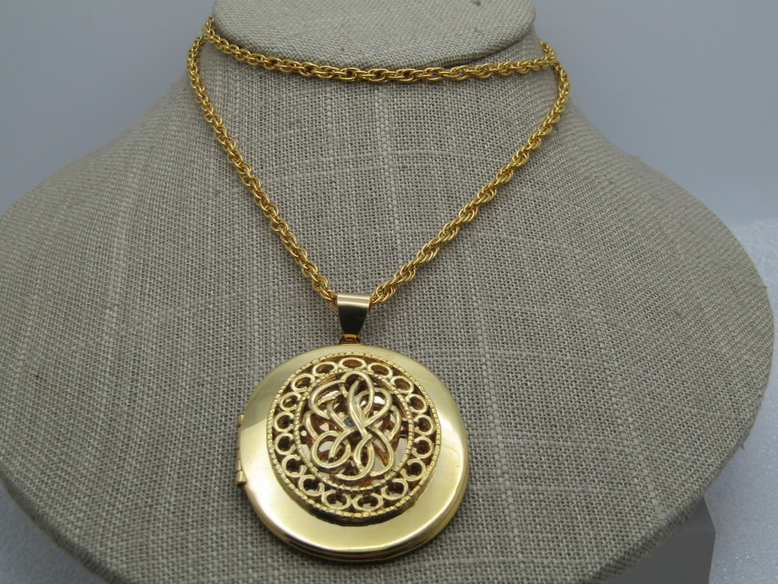 Vintage Filigree Locket Necklace, 24" 1960's-1970's: Vintage Filigree Locket Necklace, 24" 1960's-1970's. The locket is oval and appx. 2.25" tall and 1.5" wide, hinged on the left and will hold two photos. Swing bail. Gold tone chain that is appx. 2.5mm
