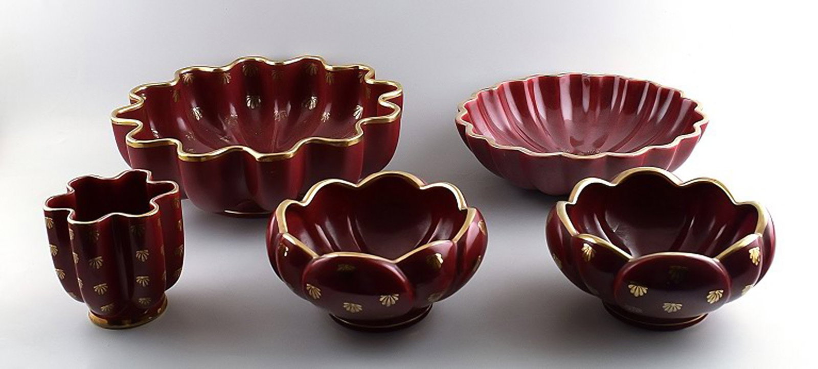 Collection of 'Red Rubin' pottery with red glaze with gold, Upsala-Ekeby, Gefle. Design Arthur: Collection of 'Red Rubin' pottery with red glaze with gold, Upsala-Ekeby, Gefle. Design Arthur Percy. Consisting of 4 bowls and 1 vase. Largest bowl measures: 29.5 x 10 cm. In perfect condition. Reser