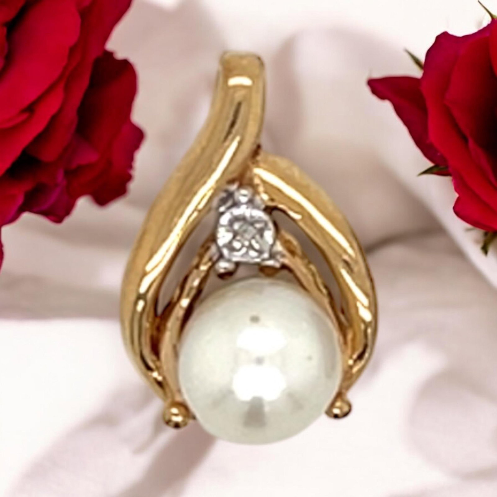 14k Yellow Gold Pearl and Diamond Pendant Drop: Vintage from before 2000 Materials: Yellow gold Gemstone: Pearl Contemporary 14k Gold Pendant with Pearl and Diamond. This pendant showcases a lustrous white pearl, elegantly cradled within a flowing 