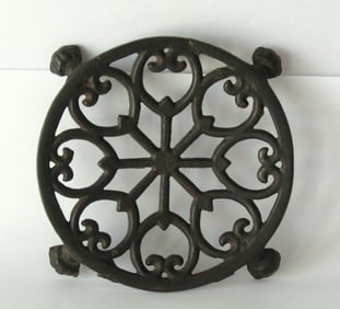 Antique cast iron round footed trivet.