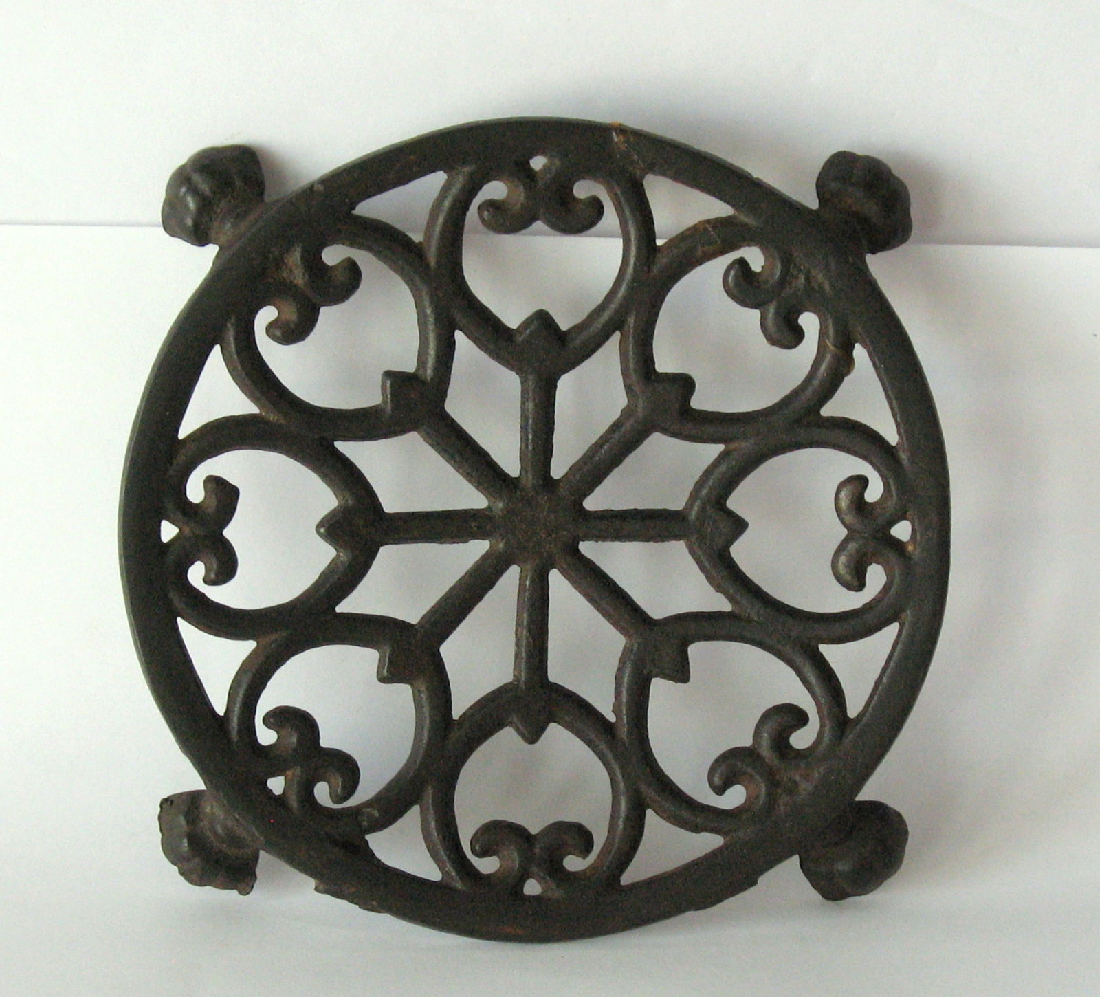 Antique cast iron round footed trivet.