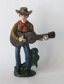 Antique cast iron cowboy with his guitar bottle opener.