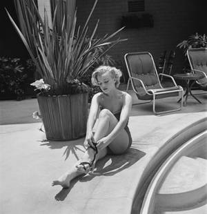 Marilyn Monroe' Circa 1951 Silver Gelatin Print Framed In White: Description 'Marilyn Monroe' circa 1951 Silver Gelatin Print Framed In White American actress Marilyn Monroe (1926 – 1962) puts on a pair of high-heeled sandals by a swimming pool, circa 1951. (