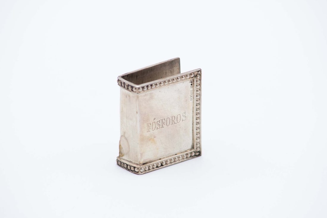Silver matchbox frame: Description: Silver matchbox frame with pearlescent trim around the edges. Metal: Silver. Origin: Portuguese. Brand: Cabeça de Rapaz - I Title. Weight: 34.51 grams | 1.22 ounces. Dimensions: 4.7x
