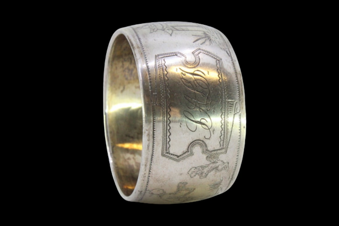 Silver napkin ring in curved shape with Asian motifs: Description: Curved silver napkin ring with Asian motifs. Metal: Silver. Origin: Portuguese. Brand: Javali II Title. Weight: 11.52 grams | 0.41 ounces. Dimensions: 4.4x2.5 cm | 1.73x0.98 inches. Purit