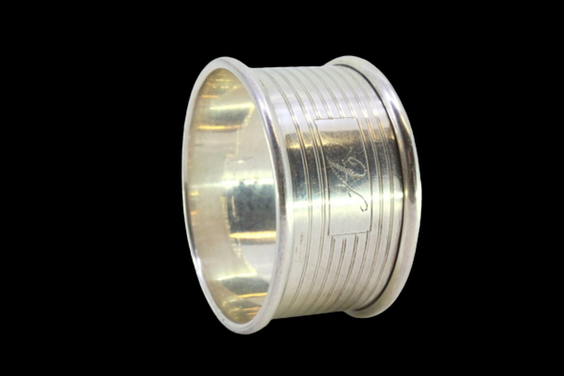 Silver napkin ring with strips surrounding a monogram card: Description: Silver napkin ring with grooves surrounding a monogram card. Metal: Silver. Origin: English. Brand: Birmingham. Weight: 11.35 grams | 0.4 ounces. Dimensions: 4.4x2.3 cm | 1.73x0.91 inches