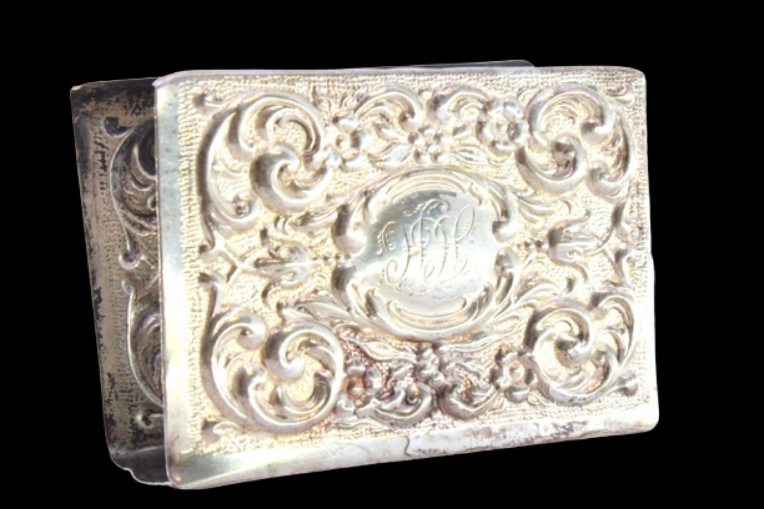 Silver matchbox frame with reliefs surrounding a monogram card: Description: Silver matchbox frame with reliefs surrounding a monogram card. Metal: Silver. Origin: English. Brand: Birmingham. Weight: 30.74 grams | 1.08 ounces. Dimensions: 7x2.5 cm | 2.76x0.98 inch