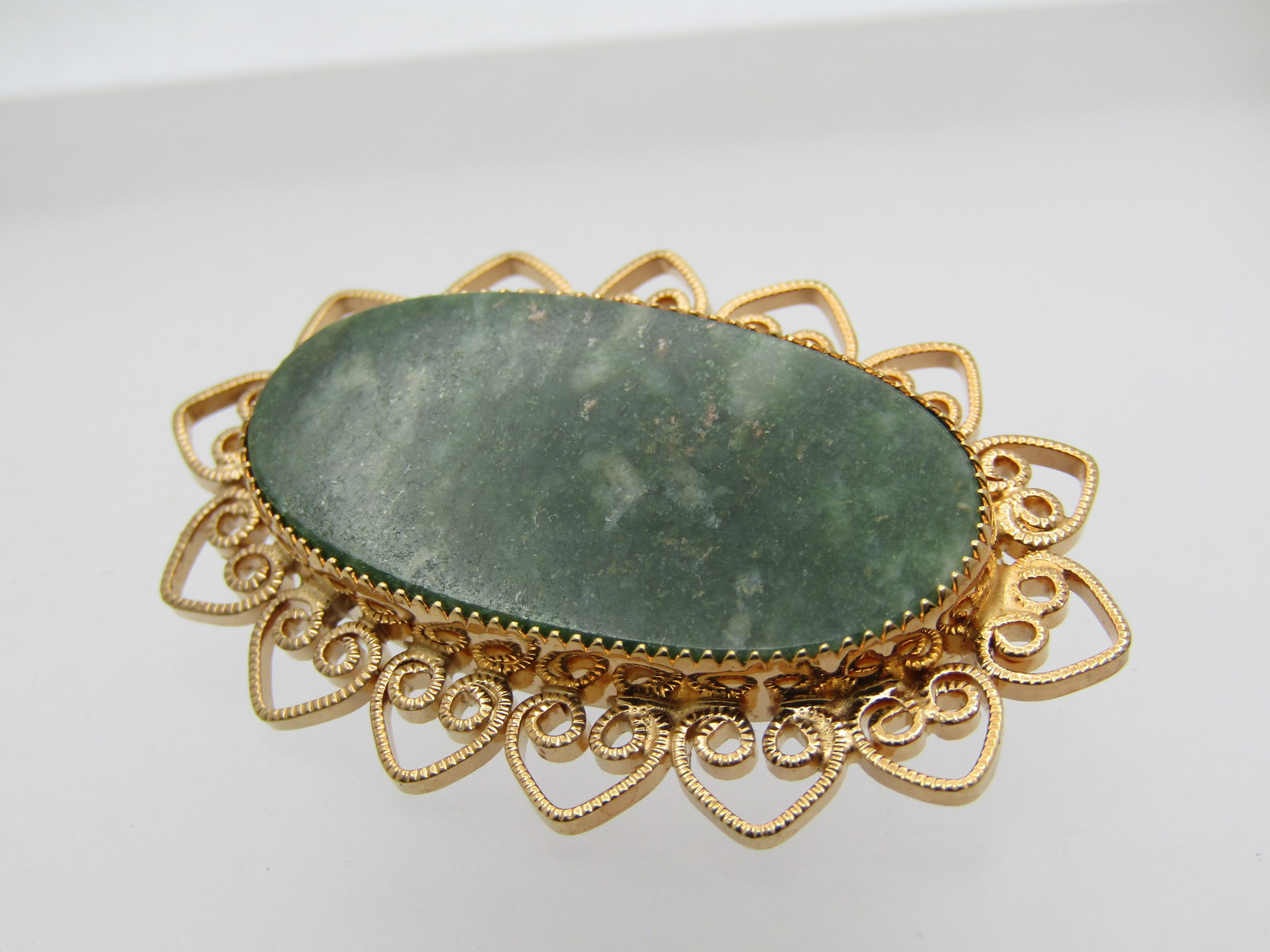 Vintage 10kt G.F. Green Agate Brooch, Heart Scrolled, 1960's-1970's: Vintage 10kt G.F. Green Agate Brooch, Heart Scrolled, 1960's-1970's. The green agate is appx. 30mm by 15mm and set with a sawtooth bzel. The lower frame extends wider and is textured heart scrolls. It