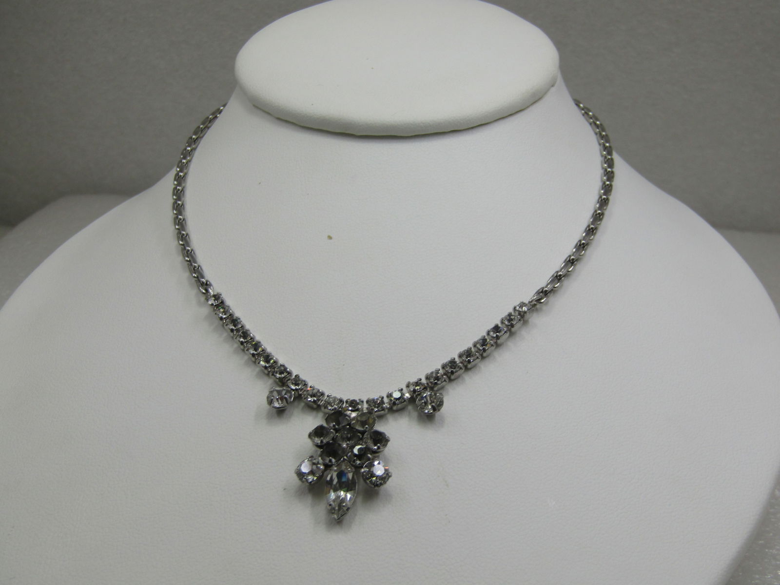 Vintage Art Deco Themed Rhinestone Drop Necklace, 15": Vintage Art Deco Themed Rhinestone Drop Necklace, 15". Rainstone chain on the front part of the neck with two 4mm round drop stones and a center blossom drop with a marquise stone bottom center and tw