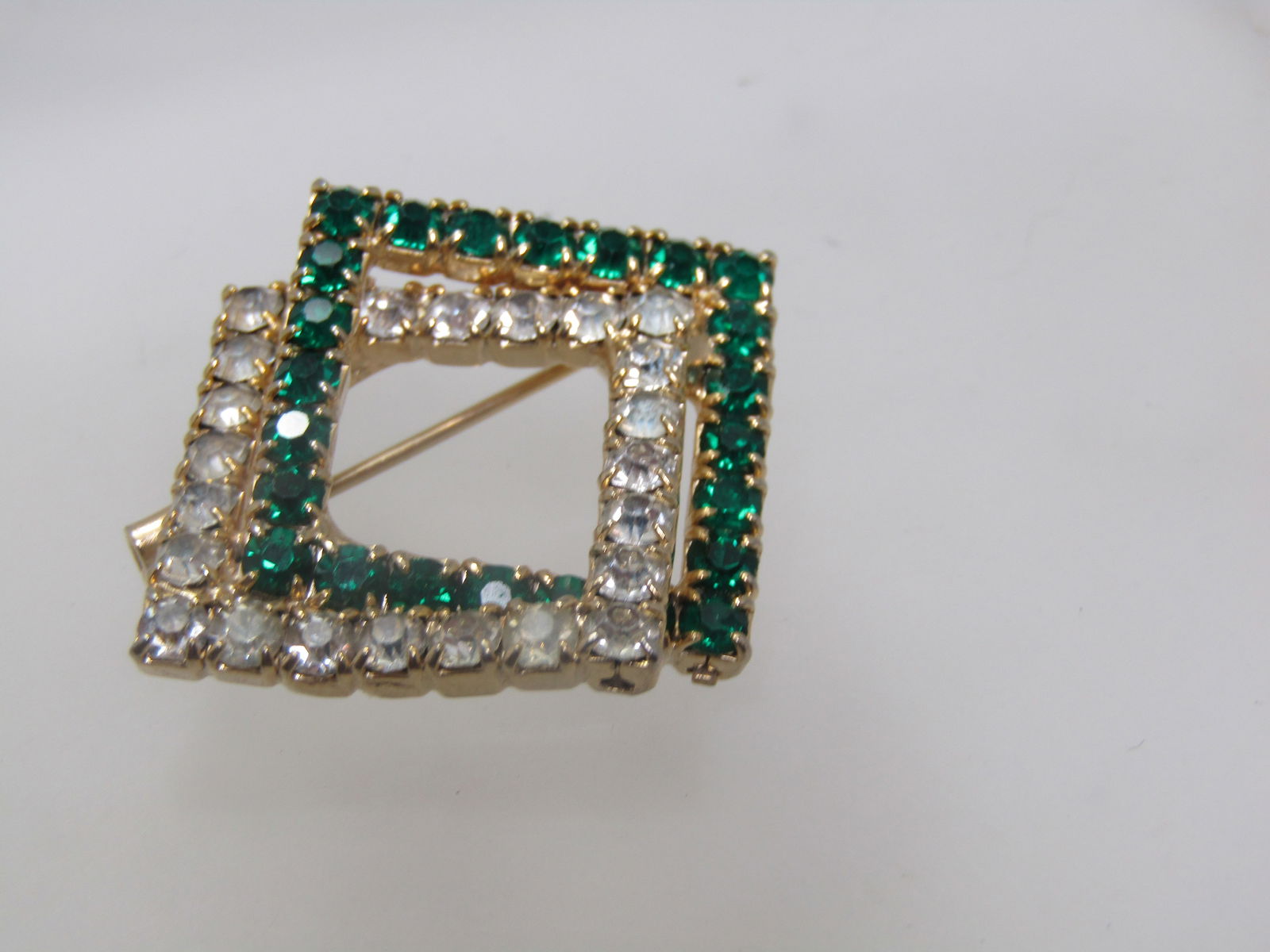 Vintage Green & Clear Rhinestone Brooch, Interwoven Squares, 1940's-1950's: Vintage Green & Clear Rhinestone Brooch, Interwoven Squares, 1940's-1950's. Gold tone setting and appx. 1" tall and 1-1/8" wide. Stones are bright and shiny and original. Not signed by the maker. (W92