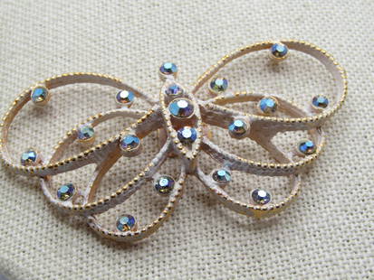 Vintage Rhinestone Butterfly Dress Clip, White Enameling, 1950's-1960's.  It is appx. wide and 1.25": Vintage Rhinestone Butterfly Dress Clip, White Enameling, 1950's-1960's. It is appx. wide and 1.25" tall with dotted like gold tone frame washed in white enameling. The rhinetones are blue aurora bore
