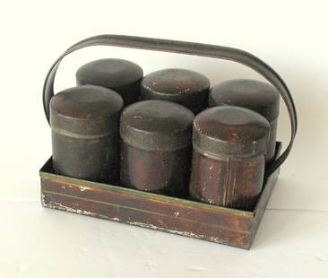 Antique set of tin spice canisters & carrier.: Title: Antique set of tin spice canisters & carrier. Date/Period: 1920's Dimension: 6 1/2&#8221; x 3 3/4&#8221; x 4 1/4&#8221; high Additional Information: Nice set of 6 antique tin spice canisters wi